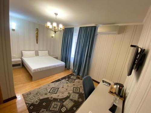 库斯塔奈Hotel Astam的小房间设有一张床和一张桌子