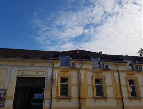 卡尼扎Viktorija Nova的黄色的建筑,有窗户,天空阴云