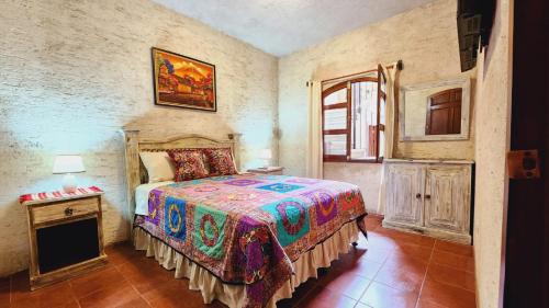 危地马拉安地瓜Casa Miranda的一间卧室配有一张床、一张桌子和一个窗户。