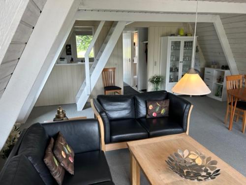 FarsøNice holiday home in beautiful resort的客厅配有黑色真皮沙发和桌子