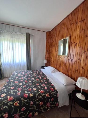 VillalagoL'Orsa的一间卧室配有一张带花卉图案的毯子的大床