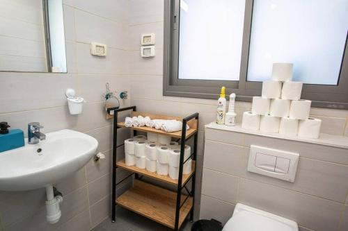 特拉维夫Amazing Dizengoff Square Home的浴室配有盥洗盆、卫生间和毛巾。