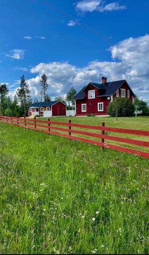 Litet hus på landet的红色房子前面的红栅栏