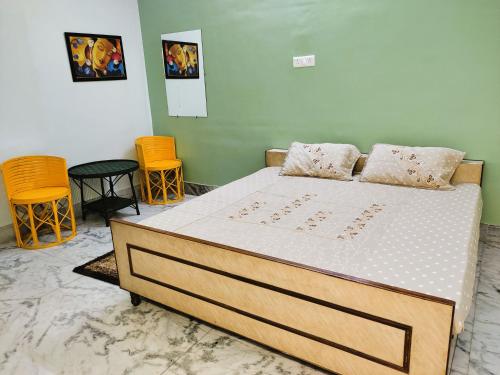 贾巴尔普尔Yellow Homestay - Modern 2BHK AC stay的一张位于带两把椅子和一张床罩的房间的床位