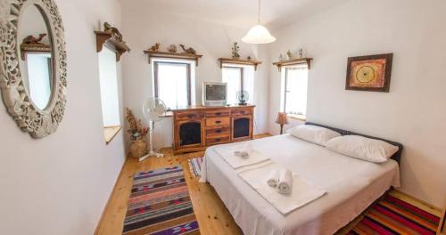 BunaCharming Cottage的一间小卧室,配有一张床和镜子