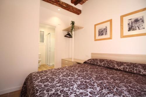 塔拉戈纳Espinach Port Serrallo的卧室配有一张床,墙上挂有两张照片