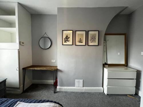 切斯特The Terrace Chester, modern 3 bed house的卧室配有三幅墙上的照片和镜子