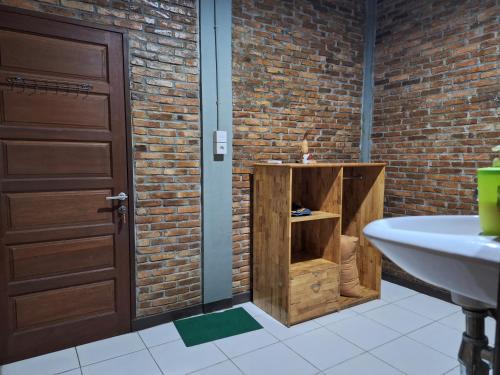 棉兰Bua Guest House的砖墙旁带水槽的浴室