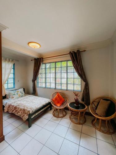 哥打京那巴鲁Shangri-La Heights Homestay的一间卧室配有一张床、两把椅子和一个窗户