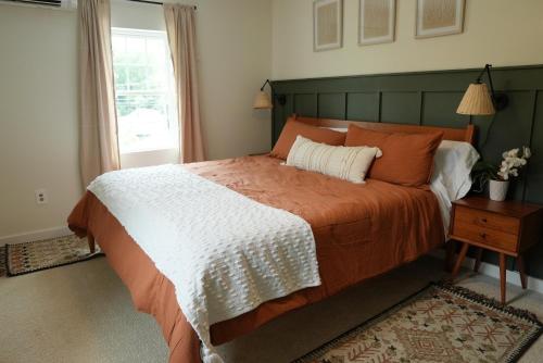 Glen RockThe Inn at Terra Farms的一间卧室配有一张带橙色和白色毯子的床
