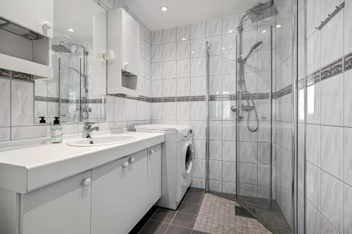 卑尔根2 min to Bryggen - Rooftop - Office with 49" Screen的白色的浴室设有洗衣机和水槽。