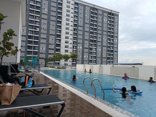 甘榜龙溪Aisy Homestay Putrajaya Cyberjaya KLIA的在大楼游泳池游泳的人