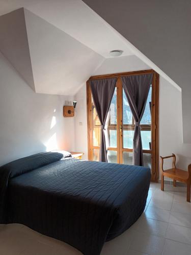 萨连特加列戈HOTEL FAMILIAR MAXIMINA的一间卧室设有一张床和一个大窗户