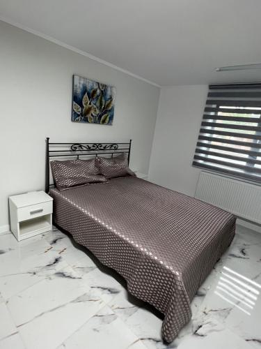 CristeştiIanis Home的一间卧室配有一张带棕色棉被的床和窗户。