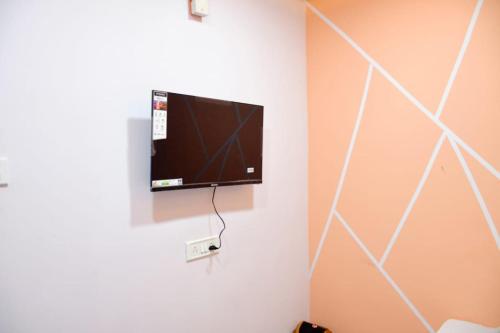 乌贾因sun guest house的挂在墙上的平面电视