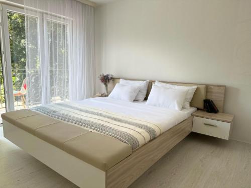 拉克塔希Apartment DUNJA Laktasi的一张大床,位于带大窗户的房间里