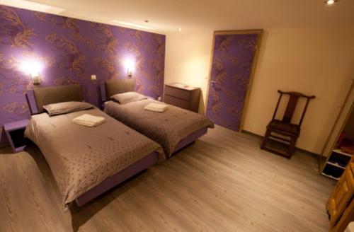 霍其多夫Hotel JiuDing的紫色墙壁客房的两张床