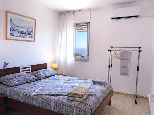 提比里亚1Bdrm APT With Panoramic View of Sea and Mountains的一间卧室设有一张床和一个窗口