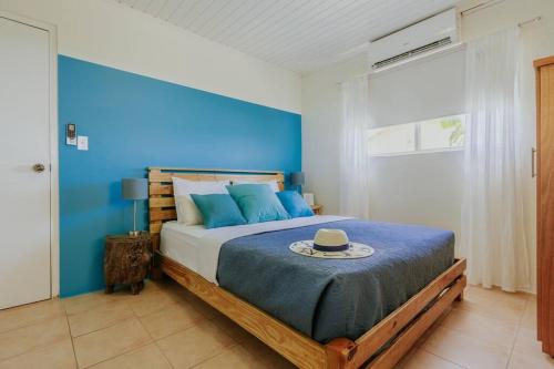 SavanetaUnbounded Horizons:Serene home with Panoramic view的蓝色卧室,配有带帽子的床