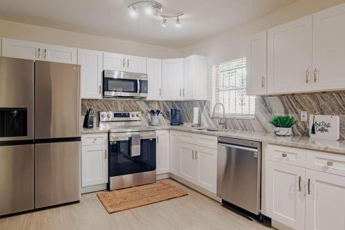 坦帕Cozy 3Bdr home in the heart of Tampa的厨房配有白色橱柜和不锈钢用具