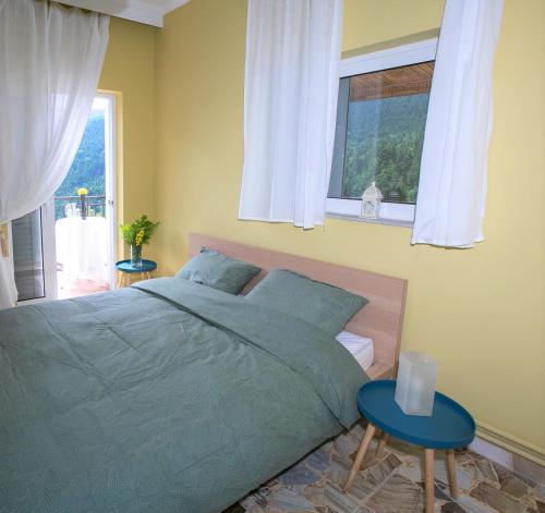 ELATALIA Plastira Lake的一间卧室配有床和两张蓝色的桌子
