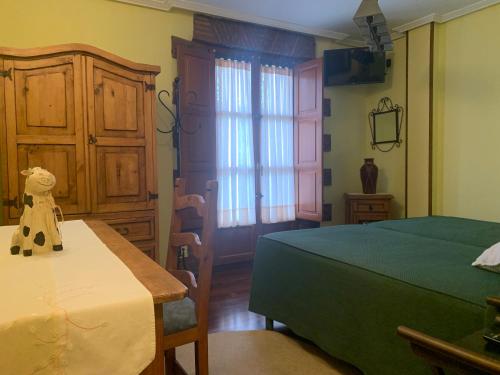 乌迪亚莱斯堡La Llosa de Sámano的一间卧室配有一张床、一张桌子和一个窗户。
