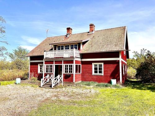 SkinnskattebergSjönära lantgård i Bergslagen的田野上带阳台的红色房子