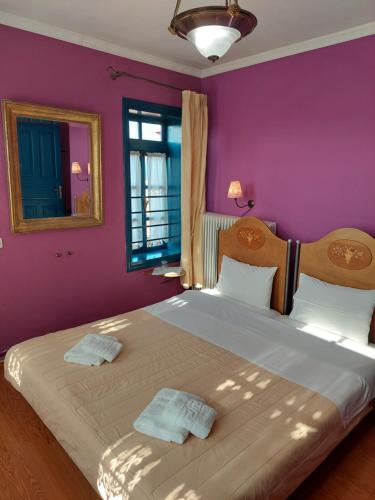 阿尔奈阿House Mitsiou Traditional Inn的一间卧室设有一张紫色墙壁的大床