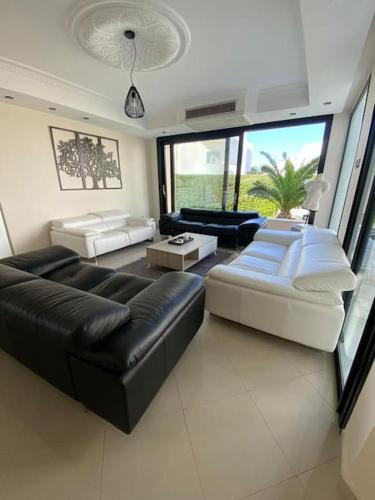 莫纳斯提尔La Villa 91的客厅配有黑色沙发和白色家具