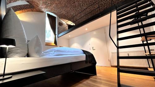 弗莱堡Historical Luxury Homes - Luxus Familien Suite的一间卧室设有一张床和一个螺旋楼梯
