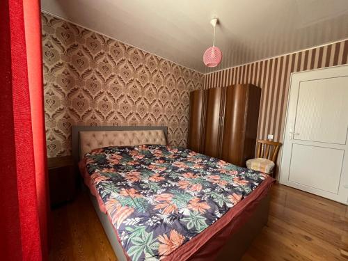 乔克-塔尔Ailus的一间卧室配有一张带花卉床罩的床
