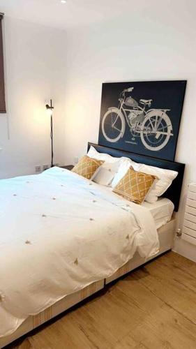 伦敦Tee SweetLux Apartment的卧室配有一张床,墙上挂着自行车的照片