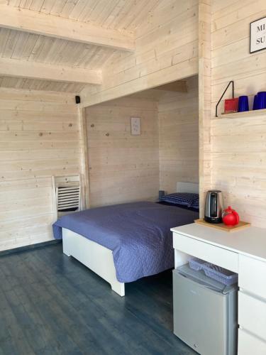 拉脱维亚WOMOCAMP Holzhütte 1的卧室配有一张床铺,位于带木墙的房间内