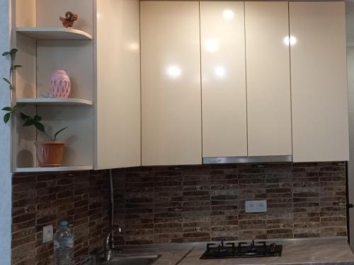 第比利斯NG Cozy App的厨房配有白色橱柜和水槽