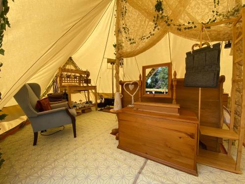 阿什伯恩Hope Cottage Bell Tent Retreat的带帐篷、椅子和梳妆台的房间