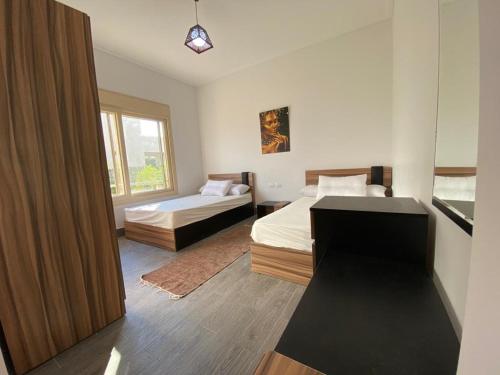 阿莱曼Hacienda Bay Luxury Chalet هاسيندا باي的一间卧室设有两张床和窗户。