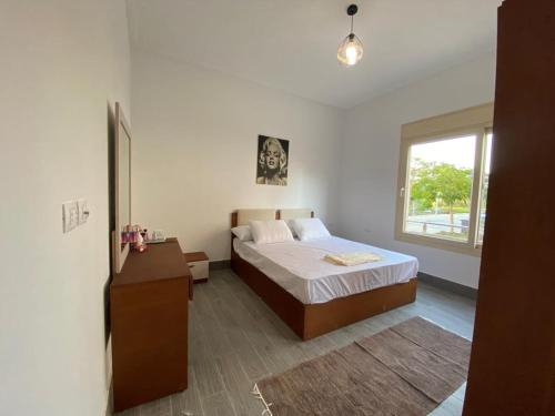 阿莱曼Hacienda Bay Luxury Chalet هاسيندا باي的一间卧室设有一张床和一个窗口