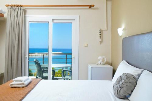 利迈纳里亚Hotel Papageorgiou的一间卧室配有一张床,享有海景