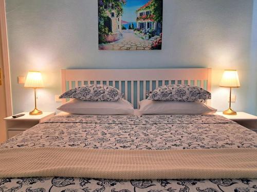 San AndrésLas Teresitas Apartment的一间卧室配有一张大床和两盏灯