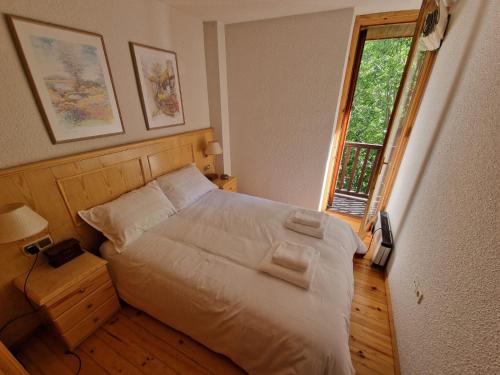 陶尔Apartamento acogedor con vistas的一间卧室配有一张带白色床单的床和一扇窗户。