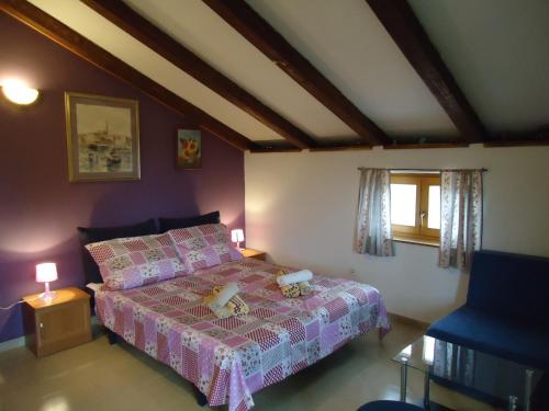 罗维尼挪拉公寓的一间卧室配有一张带粉红色床罩的床