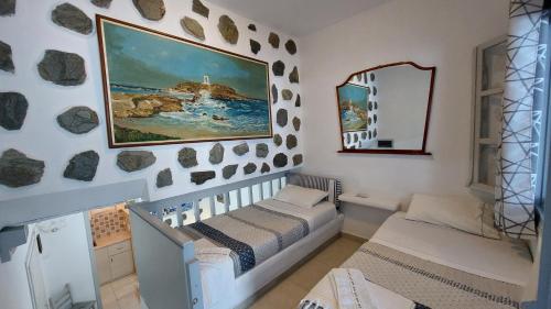 纳克索乔拉Azzurro Naxos, Azzurro I - Azzurro II - Azzurro III的一间设有婴儿床的房间和墙上的绘画
