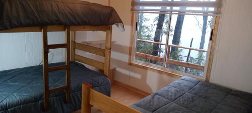 RecintoCabañas el Mirador的一间卧室配有双层床和窗户。
