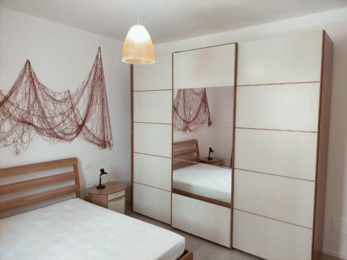 西尼加利亚Appartamento Stella Marina的一间卧室配有两张床和一个带镜子的衣柜