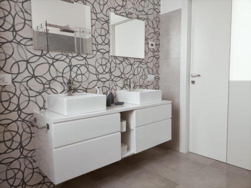 西尼加利亚Appartamento Stella Marina的浴室设有2个水槽和镜子