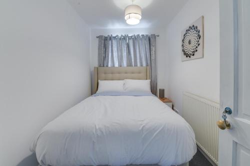 米德尔顿Farmway lodge的卧室配有白色的床和窗户。