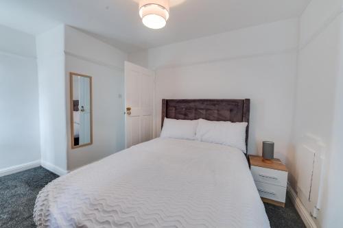 米德尔顿Farmway lodge的卧室配有一张白色大床和木制床头板
