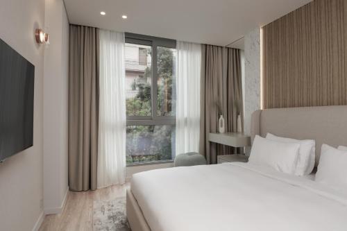 雅典Nur Aparthotel Athens的一间卧室设有一张床和一个大窗户