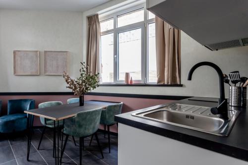 布鲁塞尔Hey - Aparthotel Brussels的厨房配有水槽和桌椅