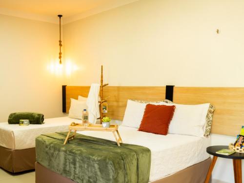 蒂安瓜Muda Hotel的酒店客房设有两张床和一张桌子。